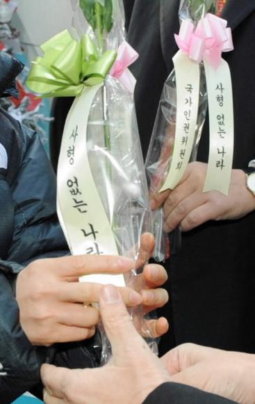24일 국가인권위원회가 서울 중구 무교동 국가인권위 건물 앞에서 출근길 시민들에게 수감중인 사형수 64명을 뜻하는 64송이의 장미꽃을 선물했다. 안주영기자 jya@seoul.co.kr