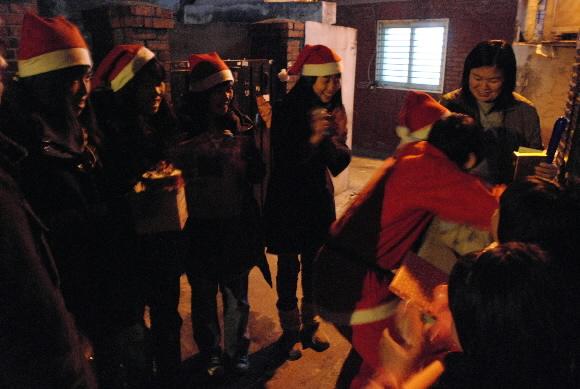 조효진(왼쪽부터 세 번째)씨와 동료들이 몰래산타로 변신하고 발달장애 영철(가명)이의 집을 방문해 영철이에게 준비한 선물을 주고 포옹을 하고 있다. 서대문청소년수련원 제공