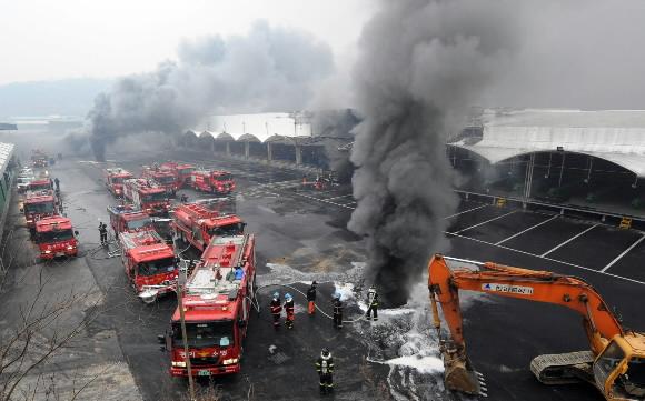 7일 경기 이천시 호법면의 물류센터 화재현장에서 소방관들이 화재진압을 위해 굴착기로 뚫어 놓은 구멍에서 검은 연기가 치솟고 있다. 이천 손형준기자 boltagoo@seoul.co.kr