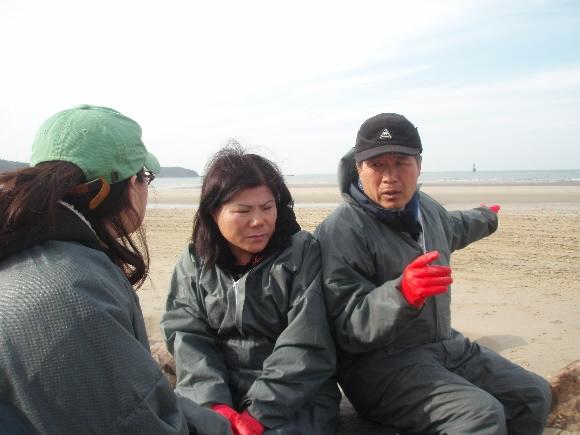 충남 태안군 신두리에서 양식업과 펜션업을 하는 선남욱(오른쪽)씨가 3일 근심이 가득한 얼굴로 검은 기름이 삼킨 굴 양식장을 가리키고 있다. 선씨와 함께 갯벌의 기름을 닦아내던 아내 정정애(가운데)씨와 딸 찬미씨도 답답한 심정에 고개를 숙이고 있다.