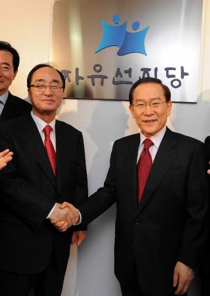 12일 합당을 선언한 자유선진당 이회창(오른쪽) 총재와 국민중심당 심대평 대표가 여의도 용산빌딩에서 선진당 당사 현판식을 가진 뒤 악수하고 있다. 최해국기자 seaworld@seoul.co.kr