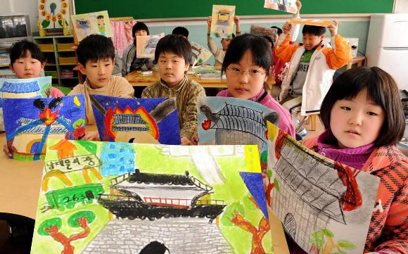 13일 오전 서울 중구 만리동 봉래초등학교 3학년 어린이들이 숭례문 화재 사건을 그린 그림을 들고 침울한 표정을 짓고 있다. 손형준기자 boltagoo@seoul.co.kr