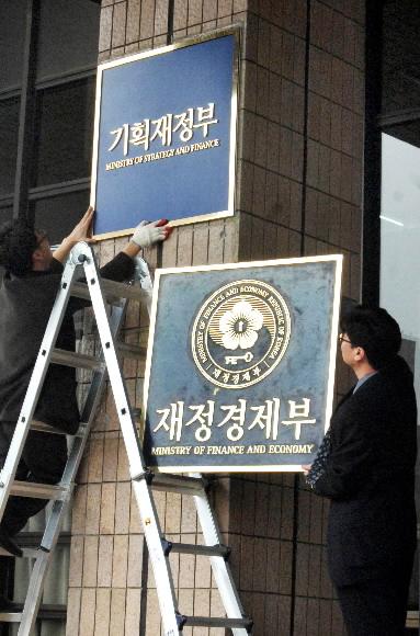 기획재정부 관계자들이 29일 오전 정부 과천청사에서 정부조직 개편 이전의 부처명이던 재정경제부 현판을 내리고 새 ‘이름표’인 기획재정부 현판을 걸고 있다. 손형준기자 boltagoo@seoul.co.kr