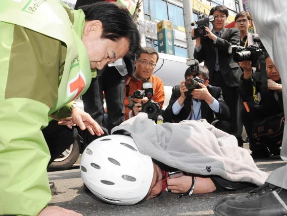 유세 일단 중단하고  통합민주당 정동영 후보가 1일 서울 동작을 선거구에서 연설하던 도중 차량과 오토바이 충돌 사고가 나자 쓰러진 오토바이 운전자에게 다가가 상태를 물어 보고 있다. 이언탁기자 utl@seoul.co.kr