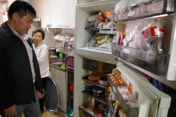 지난 3일 윤전우(왼쪽) 푸른아시아 정책팀장이 아파트내의 전기절약 방법을 설명하기에 앞서 이경순(두번째)씨 가정의 냉장고안을 살펴보고 있다. 류지영기자 superryu@seoul.co.kr