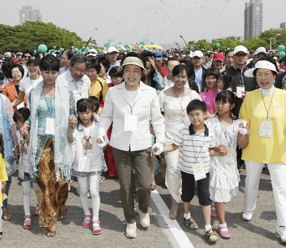 김윤옥(앞줄 가운데) 여사가 지난 17일 서울 올림픽공원에서 열린 ‘다문화가족 사랑 걷기모금 축제’에 참가해 아이들과 손을 잡고 공원 산책로를 걷고 있다. 청와대사진기자단
