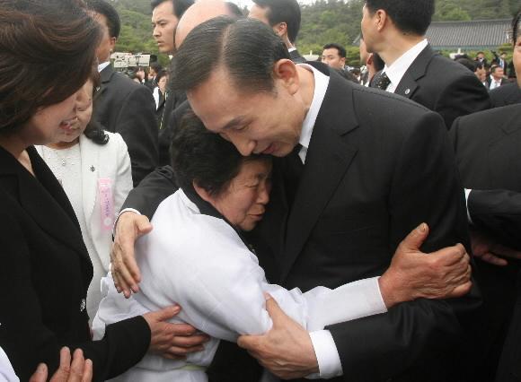 이명박 대통령이 18일 국립 5·18민주묘지에서 열린 제28주년 광주민주화운동 기념식에 참석한 뒤, 소복을 입은 한 유족을 두 팔로 안으며 위로하고 있다. 광주 청와대사진기자단