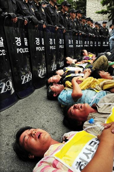 청와대행 시도 농민 21명 연행   전국농민회총연맹 소속 농민 21명이 30일 미국산 쇠고기 수입조건 장관고시 철회를 요구하며 청와대로 향하다 청운동사무소 앞에서 경찰에 저지당하자 도로에 드러누워 있다. 이들은 경찰과 몸싸움 끝에 모두 연행됐다. 도준석기자 pado@seoul.co.kr