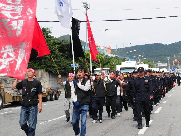 화물연대 총파업 3일째인 15일 부산항 도로에서 조합원들이 구호를 외치며 거리를 행진하자, 경찰이 질서유지를 위해 나란히 걷고 있다. 부산 왕상관기자 skwang@seoul.co.kr