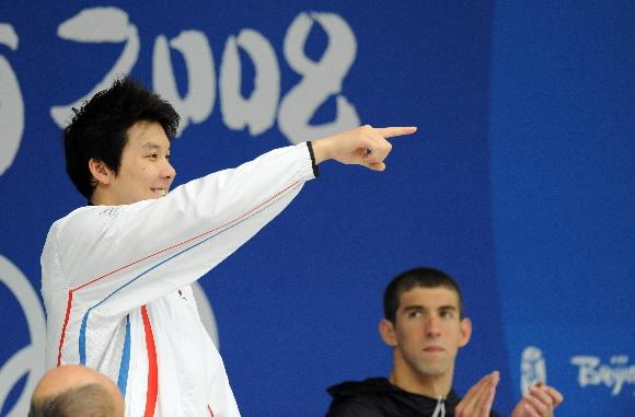 박태환(왼쪽)이 12일 수영 남자 자유형 200m 결승에서 아시아신기록으로 은메달을 따낸 뒤 시상대 위에서 관중의 환호에 답하고 있다. 세계신기록으로 금메달을 딴 마이클 펠프스가 바라보고 있다. 베이징 올림픽사진공동취재단