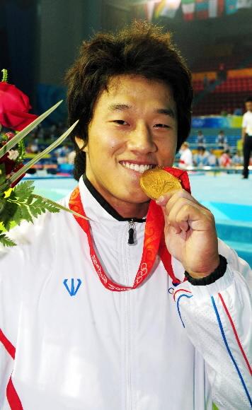 사재혁이 베이징올림픽 역도 남자 77㎏급 시상식이 끝난 뒤 금메달을 깨물어 보고 있다. 베이징 올림픽사진공동취재단