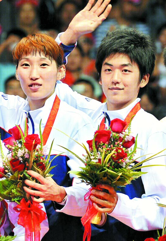 이효정(왼쪽)과 이용대가 17일 열린 배드민턴 혼합복식 인도네시아와의 결승에서 승리한 뒤 시상식에서 금메달을 목에 건 채 관중에게 손을 흔들고 있다. 베이징 올림픽사진공동취재단