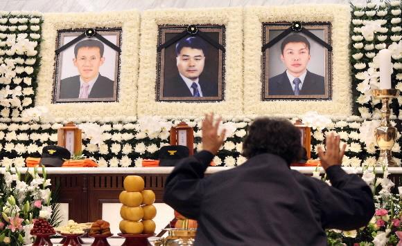 20일 서울 은평구 대조동 나이트클럽 화재로 순직한 고 변재우(사진 맨 오른쪽) 소방사의 어머니 최매자씨가 신촌 연세세브란스 병원 영안실에 차려진 합동분향소에서 오열하고 있다. 왼쪽 영정은 조기현 소방장, 가운데는 김규재 소방장.  정연호기자 tpgod@seoul.co.kr