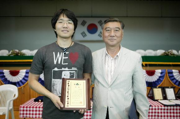 노사초배 전국아마추어바둑대회에서 아마 최강부 우승을 차지한 홍석의(왼쪽)씨가 상패를 받고 천사령 함양군수와 포즈를 취하고 있다.