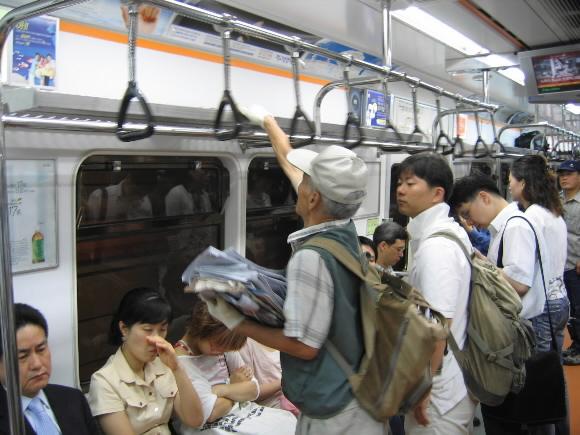 김관송씨가 23일 아침 지하철에서 신문을 모으고 있다.