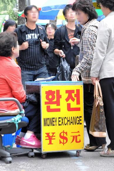 북적대는 ‘길거리 환전’  원·달러 환율이 1300원대로 폭등한 8일 서울 남대문시장에서 암달러상들이 환전하려는 손님들과 흥정을 하고 있다. 손형준기자 boltagoo@seoul.co.kr
