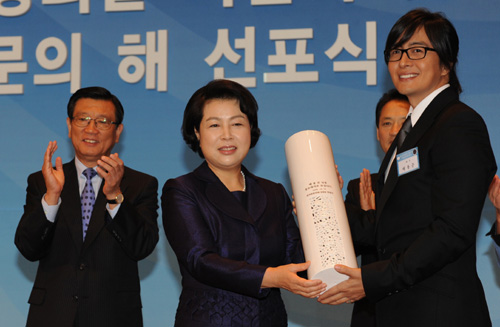 이명박 대통령 부인 김윤옥 여사가 14일 롯데호텔에서 열린 ‘한국방문의 해’ 선포식에 참석, 영화배우 배용준씨에게 홍보대사 위촉패를 전달하고 있다. 김 여사는 ‘한국방문의 해’ 조직위원회 명예위원장직을 수락했다. 왼쪽은 ‘한국방문의 해’ 위원장인 박삼구 금호아시아나그룹 회장. 최해국기자  seaworld @seoul.co.kr