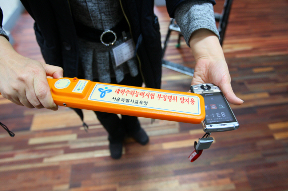 “휴대전화·MP3 안돼요”  2009학년도 대학수능시험이 치러진 13일 서울 종로구 안국동 풍문여고에서 한 감독관이 휴대전화·MP3 등 금지품목을 검색하기 위해 지급된 금속탐지기가 제대로 작동하는지 시험하고 있다. 손형준기자 boltagoo@seoul.co.kr