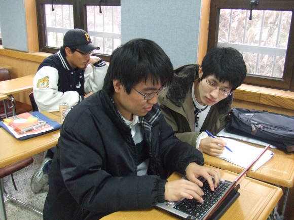 서울대에 다니고 있는 청각장애인 이동엽(오른쪽)씨가 2일 수업시간에 옆자리 도우미 학생이 노트북에 받아 친 강의 내용을 유심히 바라보고 있다.