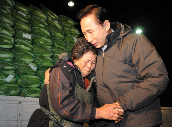 4일 새벽 서울 가락동 농수산물시장을 찾은 이명박 대통령이 배추를 팔고 있는 한 할머니가 장사가 안된다며 울먹이자 손을 잡으며 위로하고 있다. 최해국기자 seaworld@seoul.co.kr