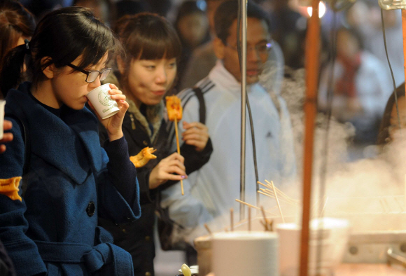 동장군이 본격적으로 맹위를 떨치면서 올 들어 첫 한파주의보가 발효된 4일 서울 명동에 나온 시민들이 어묵꼬치와 국물을 마시며 언 몸을 녹이고 있다.  정연호기자 tpgod@seoul.co.kr