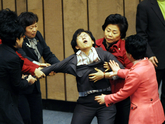 민주노동당 이정희(가운데) 의원이 12일 밤 국회 본회의장 단상에서 한나라당 여성 의원들에게 끌려 내려오고 있다. 김명국기자 daunso@seoul.co.kr 