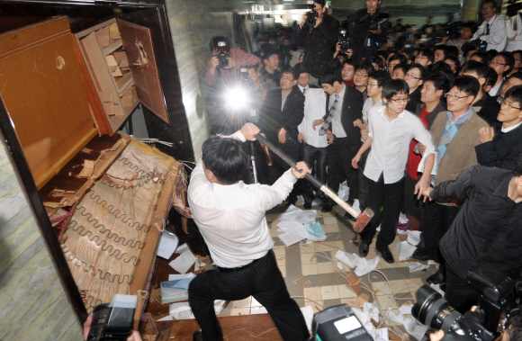 난장판  한나라당이 한·미 FTA 비준동의안을 단독 상정한 18일 민주당의 한 당원이 국회 외교통상통일위원회 회의장에 진입하기 위해 망치로 바리케이드를 내리치고 있다. 김명국기자 daunso@seoul.co.kr 