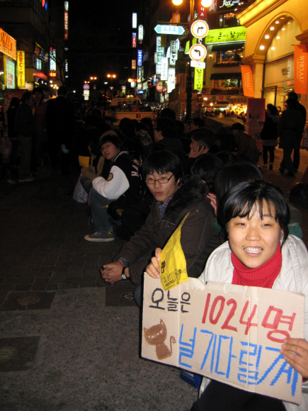 매일 두 배씩 숫자를 불려가는 네티즌들이 19일 서울 명동에서 줄지어 앉아 있다.