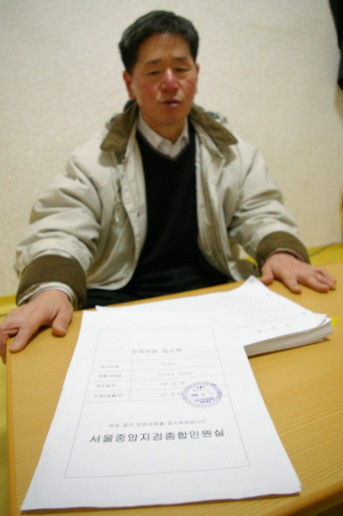 15년째 공권력을 상대로 법정투쟁 중인 이산해씨가 사건 서류를 보여주고 있다. 