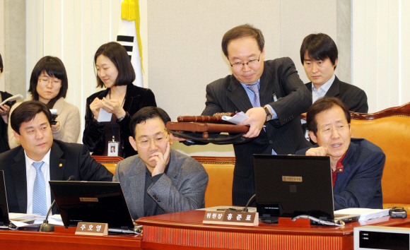 홍준표(오른쪽 첫번째) 한나라당 원내대표가 24일 국회 운영위원회 회의실에서 미리 위원장 좌석 주변에 앉아 있던 민주당 의원들을 향해 여당 단독으로 법안 처리를 하지 않겠다며 국회 직원에게 의사봉을 치우게 하고 있다. 김명국기자 daunso@seoul.co.kr