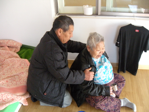 노숙생활을 청산하고 재기에 성공한 윤창원씨가 31일 새로 입주한 임대주택에서 어머니의 어깨를 주무르고 있다.