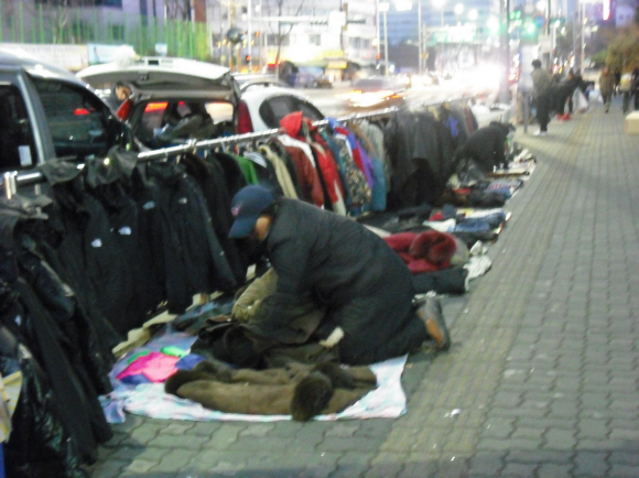 서울 신설동 풍물시장 주변 거리에서 옷을 팔고 있는 옛 청계천 상인이 15일 오후 손님이 없자 노점을 정리하고 있다.