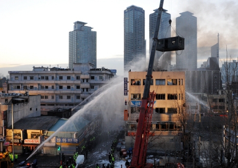 20일 새벽 서울 용산 4구역 철거민대책위원회 회원들이 농성중인 한강대로변 재개발지역의 한 건물에서 경찰의 강제진압이 진행되고 있는 가운데 건물 옥상에서 불이 타오르고 있다. 정연호 tpgod@seoul.co.kr