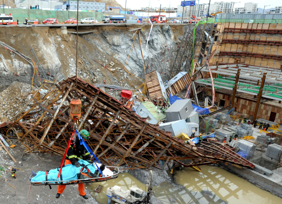 15일 오전 붕괴된 경기 성남시 동판교 택지개발지구 SK케미칼연구소 공사현장에서 소방관계자들이 부상자를 크레인으로 구조하고 있다.  이호정기자 hojeong@seoul.co.kr