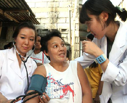 필리핀 앤젤레스시 빈민가 빈터에서 대구보건대 간호과 박지윤(왼쪽 ·25)씨와 김서하(오른쪽·20)씨가 한 주민의 혈압을 재는 등 의료 봉사활동을 펴고 있다.