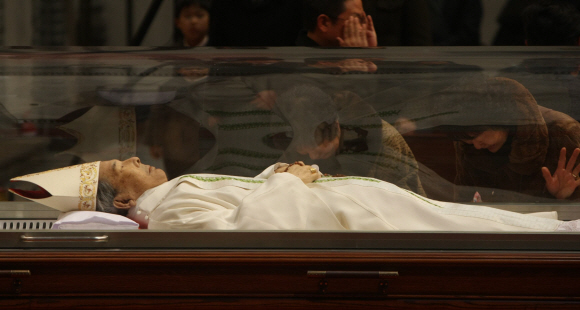 16일 선종한 김수환 추기경의 시신이 흰색 제의에 모관을 갖춰 입은 모습으로 서울 명동성당 대성전에 마련된 유리관에 안치된 가운데 소식을 듣고 달려온 시민들이 차마 추기경을 바라보지 못한 채 오열하고 있다. 이언탁기자 utl@seoul.co.kr 