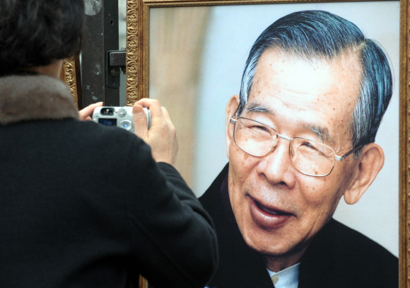 “당신의 웃음 속에 담긴 사랑과 희생의 정신을 따르겠습니다.” 조문 마지막 날인 19일 한 여성이 서울 명동성당 종마루 옆 난간에서 전시중인 김수환 추기경의 활짝 웃는 모습을 카메라에 담고 있다. 정연호기자 tpgod@seoul.co.kr