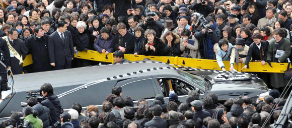 눈물의 배웅  김수환 추기경의 운구 차량이 20일 오전 서울 명동성당에서 경기 용인공원 성직자 묘역으로 길을 나서려 하자 시민들이 슬픔에 젖은 표정으로 마지막 배웅을 하고 있다. 운구차를 어루만지며 추기경을 떠나보내는 안타까운 심정을 드러내는 모습도 보인다. 안주영기자 jya@seoul.co.kr