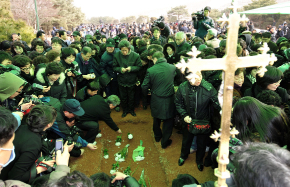 마지막 인사 20일 경기도 용인시 용인천주교공원 성직자 묘역에서 열린 김수환 추기경 하관식에서 시민들이 영원한 안식을 기원하며 국화를 올리고 있다. 사진공동취재단