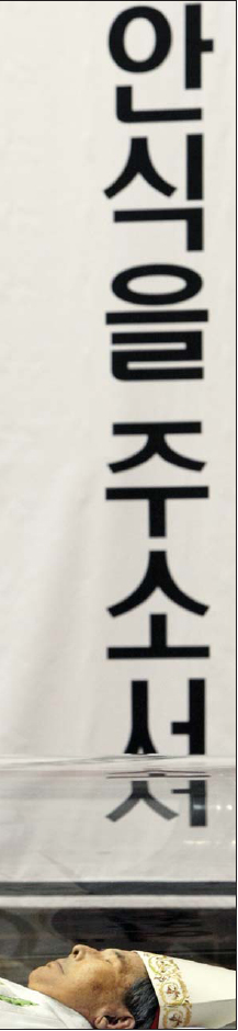 안식을 주소서  16일 김수환 추기경이 서울 강남성모병원에서 선종한 뒤 명동성당으로 옮겨진 직후 공개된 모습이다. 김 추기경이 안치된 유리관 너머로 ‘안식을 주소서’라는 기도문이 보인다.