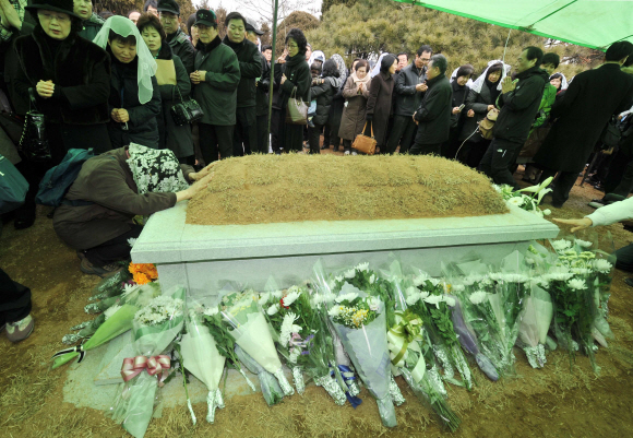 22일 김수환 추기경 추모미사가 열린 서울대교구 용인공원묘지의 성직자묘역에서 추도객들이 묘소에 헌화하며 고인의 안식을 기원하고 있다.  용인 안주영기자 jya@seoul.co.kr 