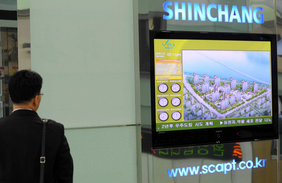 9일 법정관리 신청 소식을 듣고 걱정돼 신창건설 안양 본사를 찾은 입주 예정자가 대형 화면에 비친 공사 중인 아파트 조감도를 바라보고 있다. 류재림기자 jawoolim@seoul.co.kr