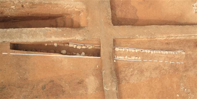 부여 능산리 절터 발굴 현장에서 드러난 백제시대 석렬유구. 한국전통문화학교 발굴조사단은 막돌을 두 줄로 깔고 가운데는 적갈색 흙을 깔아놓은 이 유적이 경주 감은사 금당터의 지하유구처럼 매우 특별한 용도로 쓰였을 것으로 추정하고 있다. 문화재청 제공