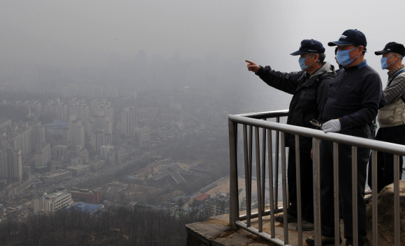 “저기가 어디야” 올 들어 두 번째 황사주의보가 내려진 16일 서울 서대문구 안산에 오른 시민들이 마스크를 쓴 채 황사로 뿌옇게 뒤덮인 서울 일대를 가리키며 내려다보고 있다. 류재림기자 jawoolim@seoul.co.kr