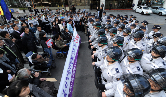30일 서울 세종로 정부중앙청사 후문에서 ‘국가인권위 독립성 보장 및 축소 철회를 위한 인권시민사회운동진영 공동투쟁단’ 회원들이 인권위 축소 방침 국무회의 통과 반대 기자회견을 가진 뒤 청와대로 가려다 경찰과 대치하고 있다.  손형준기자 boltagoo@seoul.co.kr 