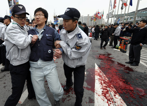 3일 고양시 일산 킨텍스에서 서울모터쇼가 개막된 가운데 전국금속노동조합원들이 행사장 앞에서 기자회견을 열고 퍼포먼스를 진행하다 경찰에 연행당하고 있다. 　고양=연합뉴스