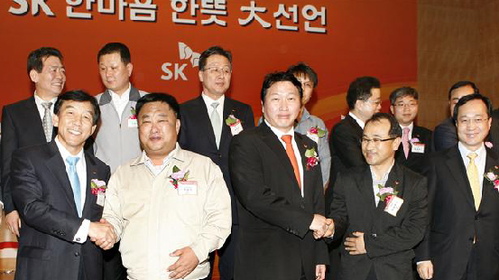 8일 최태원(앞줄 오른쪽 세번째) SK 회장이 계열사 최고경영자들이 지켜보는 가운데 이상일 SK C&C 구성원 대표와 고통 분담·고용 안정에 합의한 뒤 악수하고 있다.  SK 제공 