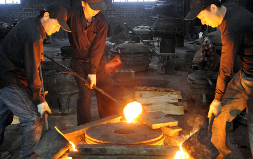 전통기법의 가마솥 공장인 안성주물의 종업원들이 섭씨 1850도로 펄펄 끓는 쇳물을 받아 가마솥 모양의 거푸집(틀)에 붓고 있다.