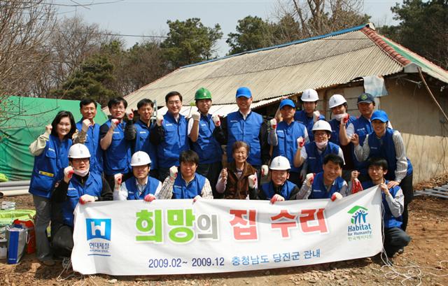 현대제철 우유철(사진 뒷줄 왼쪽에서 일곱번째) 사장과 임직원들이 첫 번째 ‘희망의 집수리 사업’ 가정인 이종분(사진 앞줄 가운데) 할머니집을 방문해 봉사활동을 마친 뒤 파이팅을 외치고 있다. 현대제철 제공 