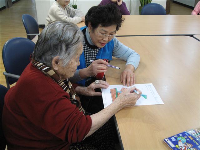 이희순(오른쪽) 할머니가 치매노인의 자활학습을 돕고 있다.  광진구 제공 